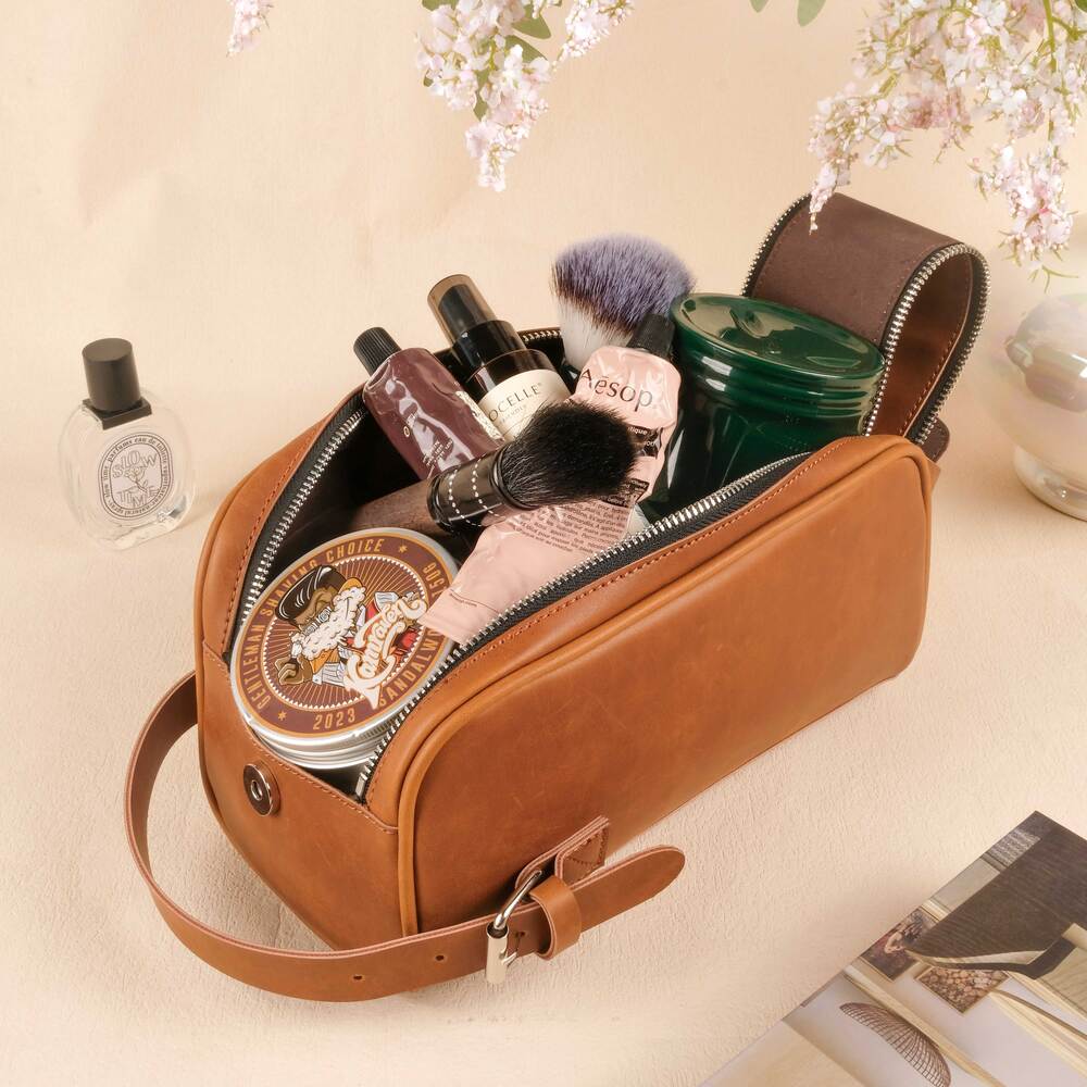 Brown leather toiletry bag with cosmetic items on a light background