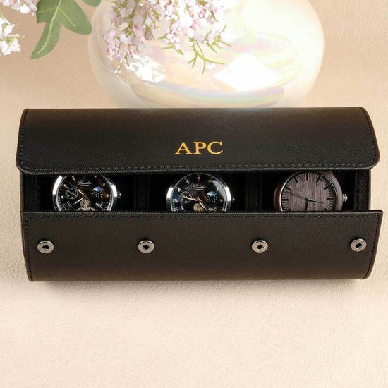 Black watch case with three watches on a beige surface, featuring the brand 'APC'.