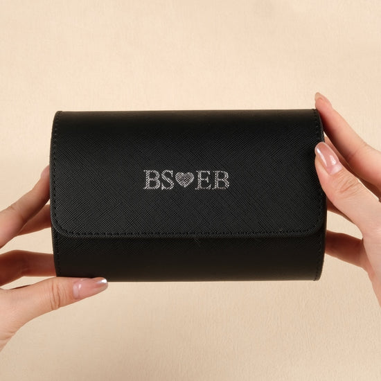 Black wallet held by hands with 'BS❤️EB' branding on a beige background