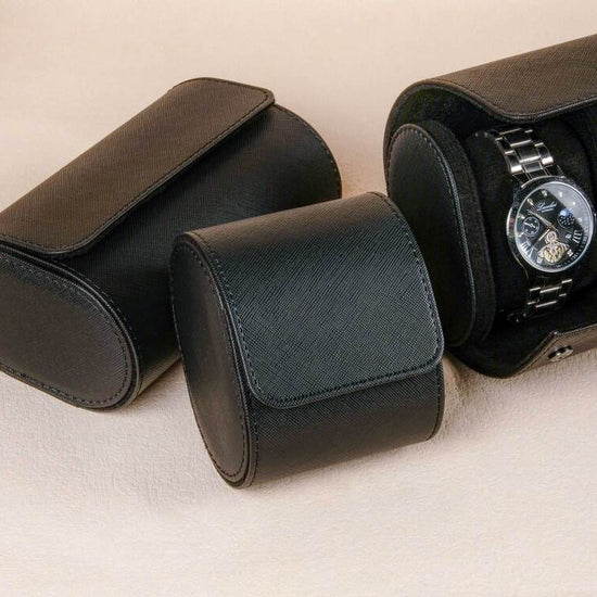 Black watch case with two watches on a beige background