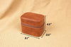 Brown leather jewelry box with dimensions on a beige fabric background