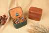 Two leather jewelry boxes, one open with watches inside, on a textured beige surface.