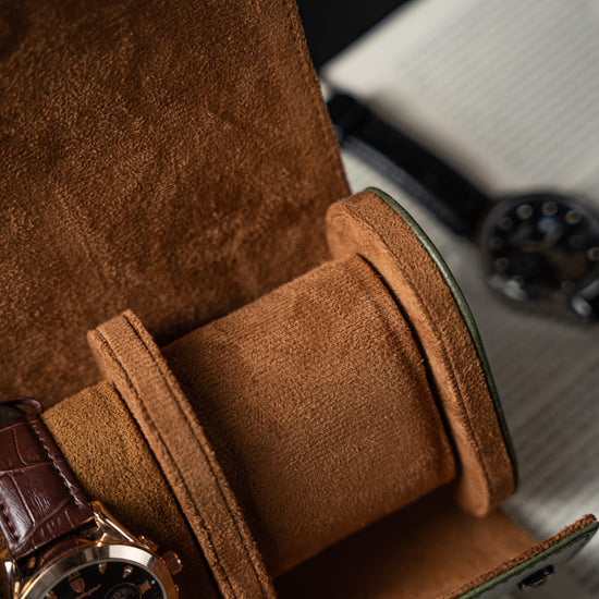 Brown leather watch case with a watch inside, on a blurred background