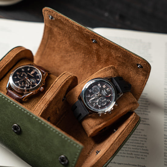 Two watches in a brown leather case on a book